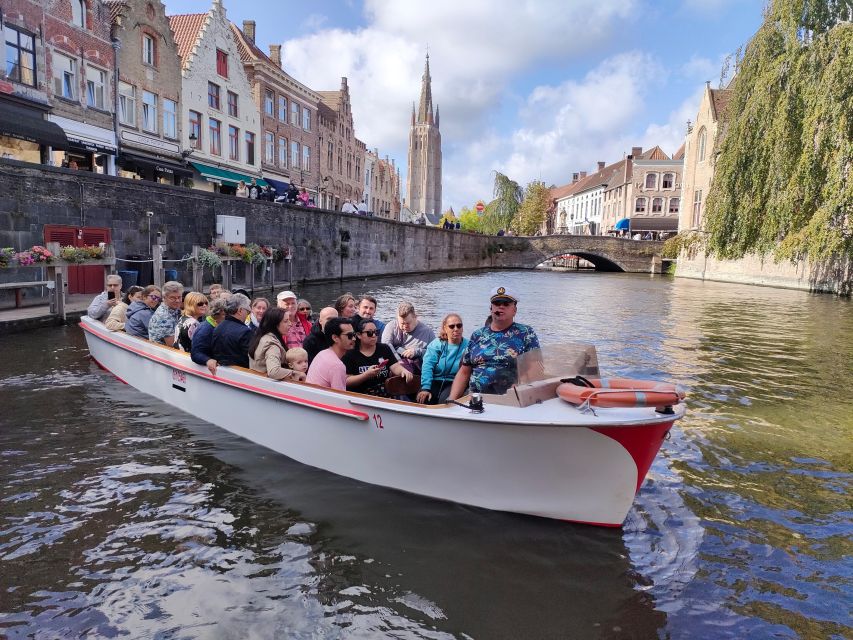 Bruges: Small Group Boat Cruise and Guided Walking Tour - The canal cruise: ivy facades, bridges, and swans near the Beguinage